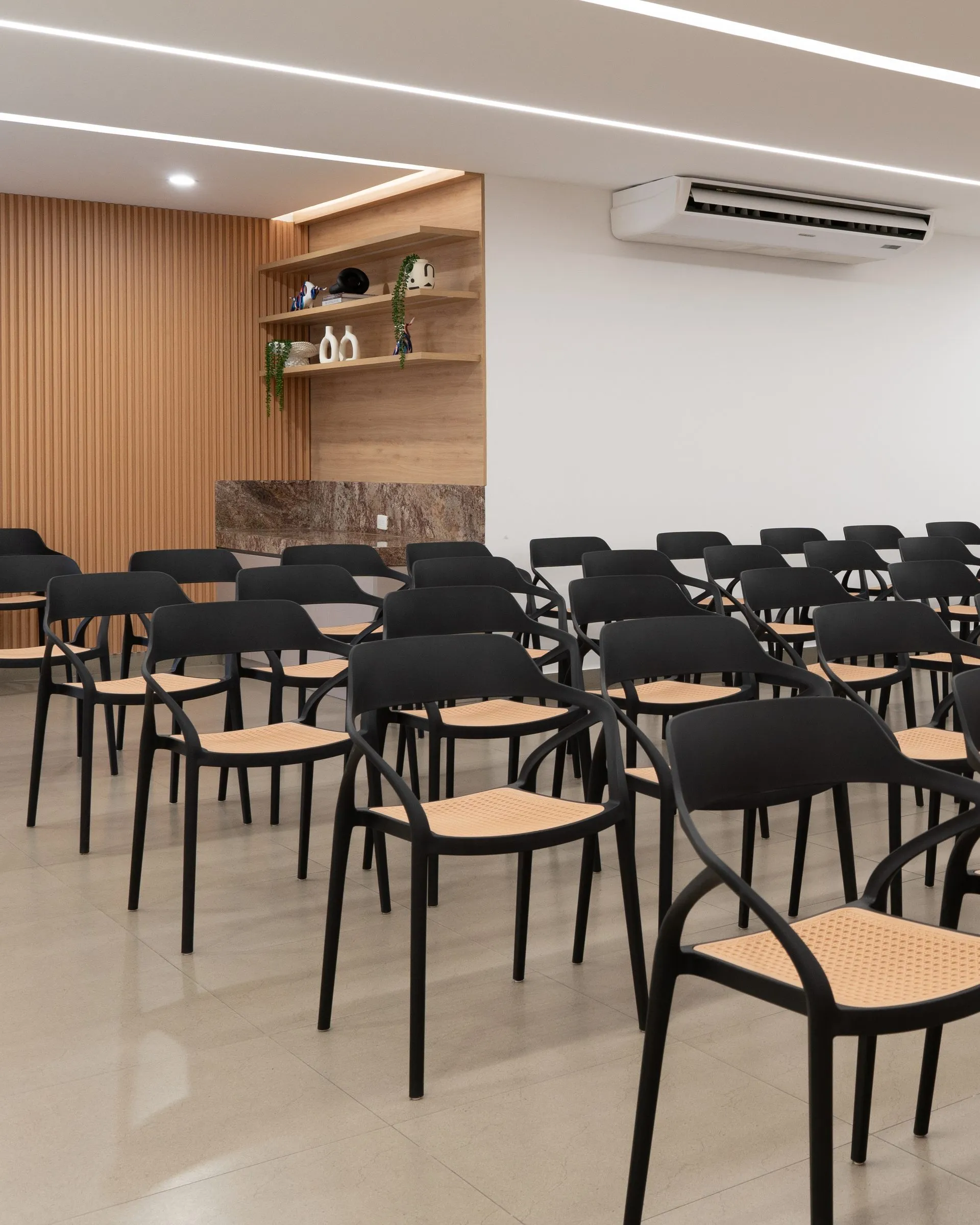 Filas de sillas negras con asiento de ratán en el auditorio